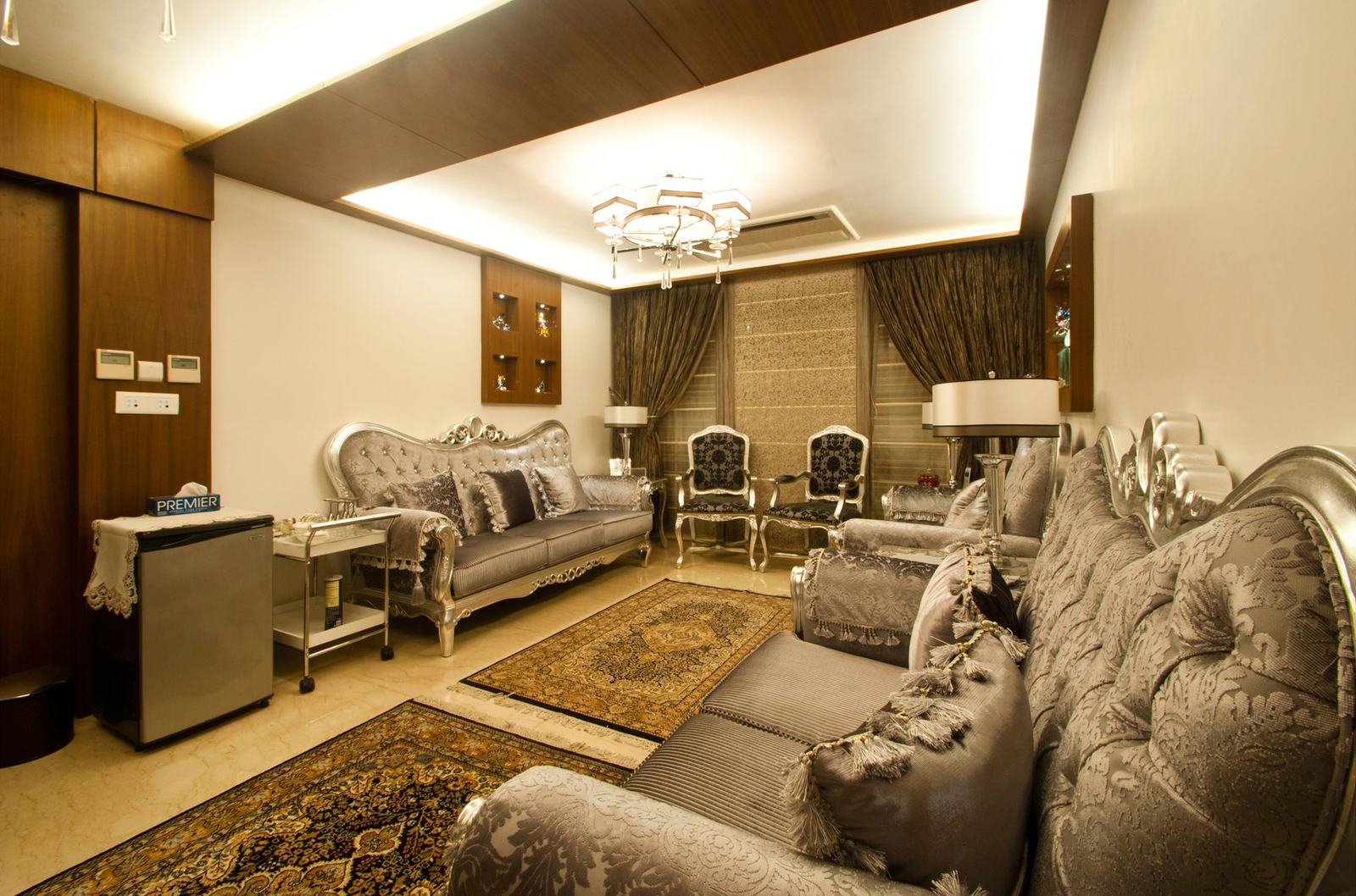 Formal living room with silver sofas and a chandelier in the Aspirin Residence by Feel and Bari