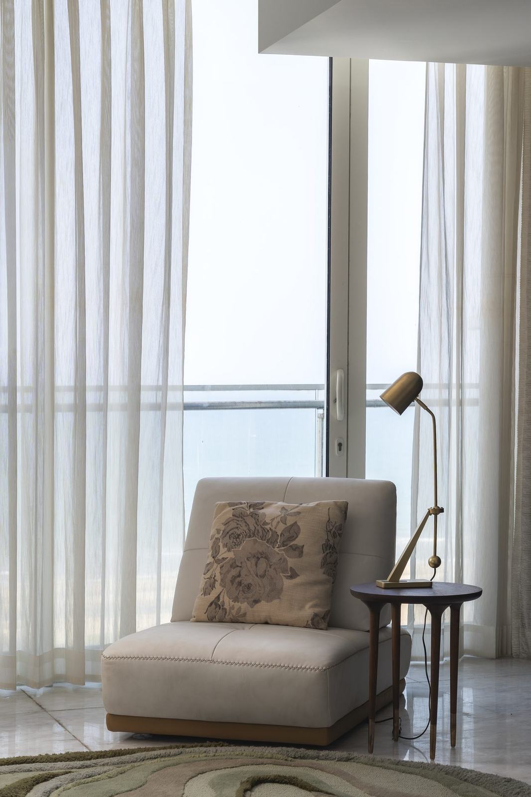 Living room reading nook with a brass lamp in Rio The Penthouse by Feel and Bari