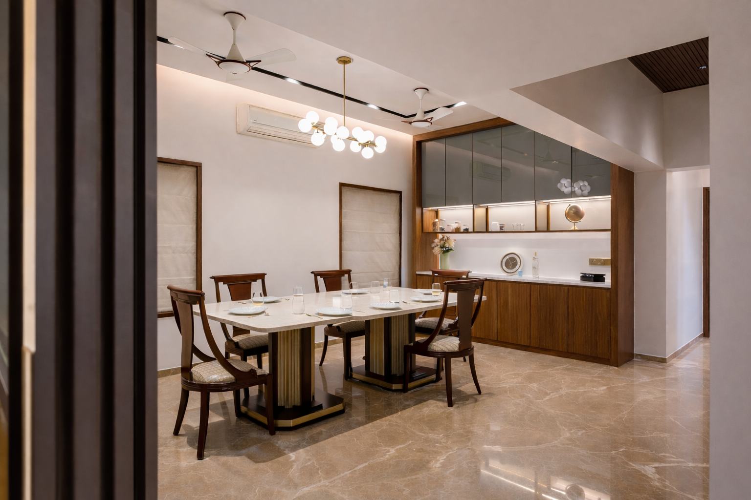 Dining room with an atomic chandelier and marble table in That House by Feel and Bari